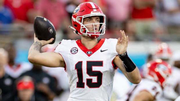 Georgia Bulldogs quarterback Carson Beck attempts a pass during a college football game in the SEC.